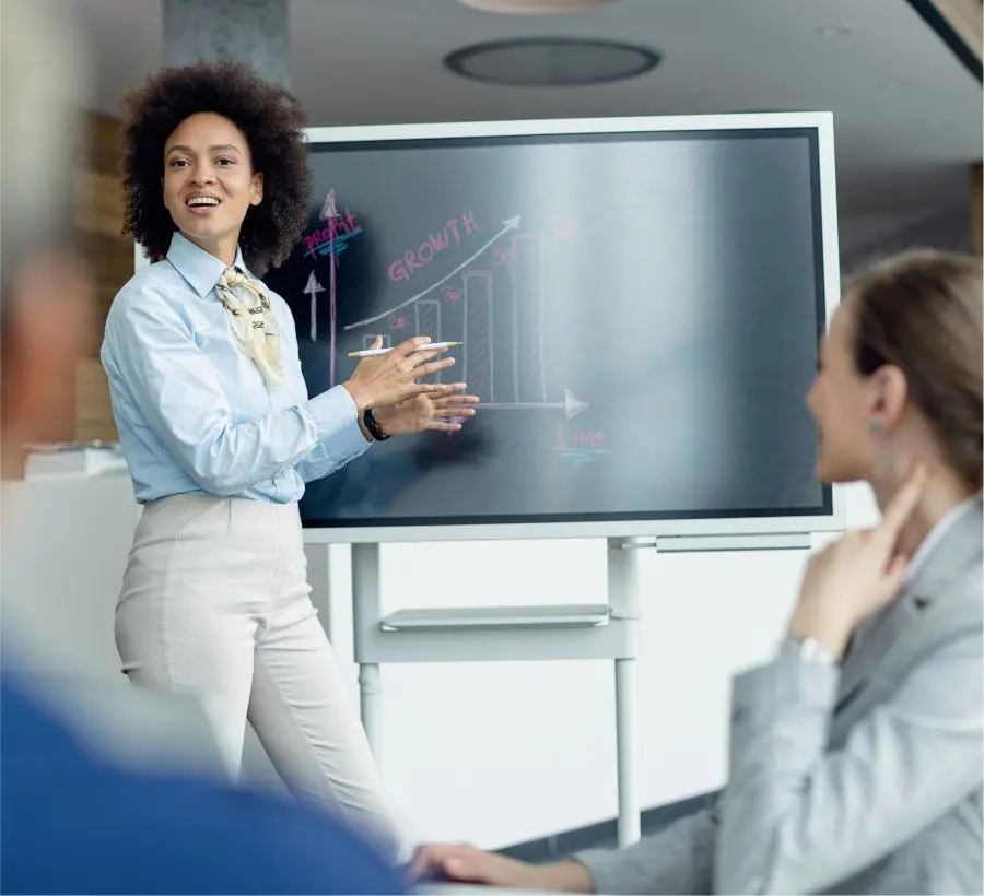 Une femme fait une présentation à son équipe.