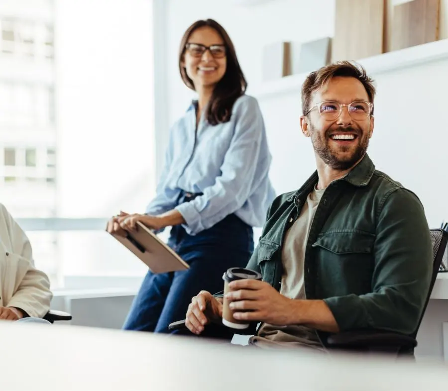 Un homme et une femme souriants regardent de côté hors de l'image...