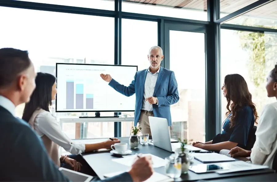 Un homme fait une présentation à un groupe d'auditeurs dans une salle de conférence....