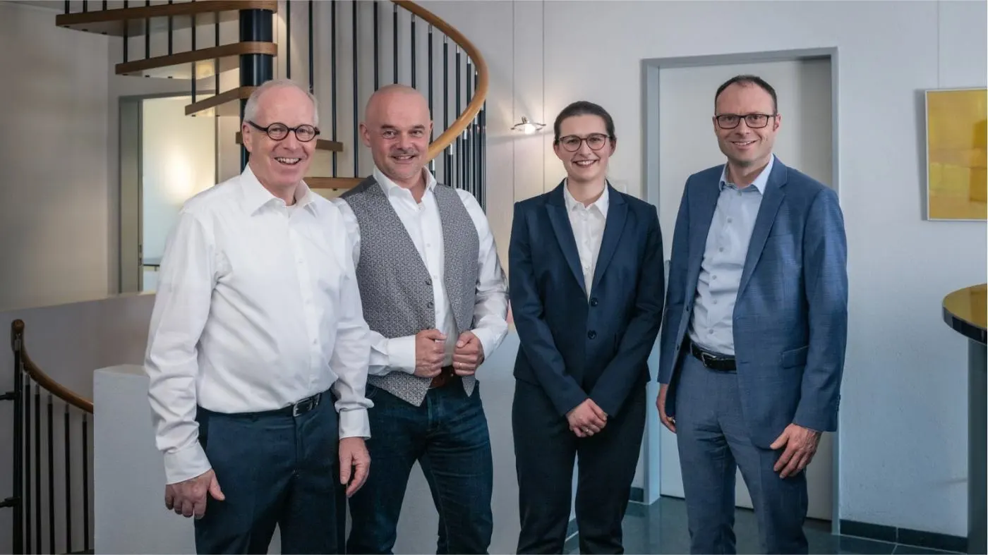 Photo de groupe de l'équipe future-cube devant l'escalier en colimaçon de leur bureau.